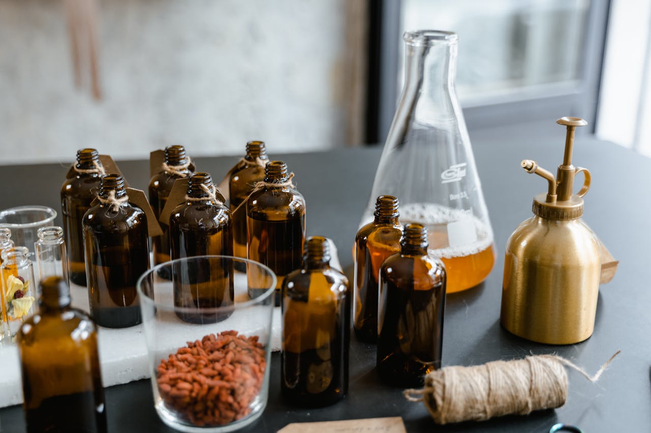 A variety of glass bottles with essential oils and herbs for aromatherapy.